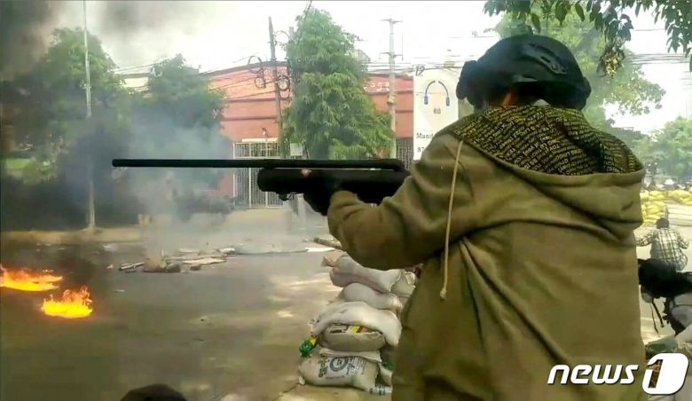 28일 (현지시간) 미얀마 만달레이에서 군사 쿠데타를 규탄하는 시위대가 군경과 충돌 중 총을 조준하고 있다. © AFP=뉴스1 © News1 우동명 기자