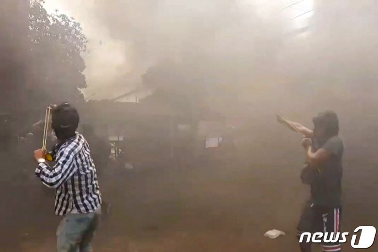 29일(현지시간) 미얀마 양곤에서 군사 쿠데타에 반대하는 시위대가 군경과 충돌 중 새총을 쏘고 있다. © AFP=뉴스1 © News1 우동명 기자