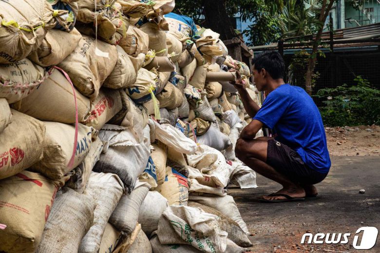 30일 (현지시간) 미얀마 양곤에서 군사 쿠데타에 반대하는 시위대가 군경과 충돌 중 바리케이드 뒤에서 상황을 살펴보고 있다. © AFP=뉴스1 © News1 우동명 기자