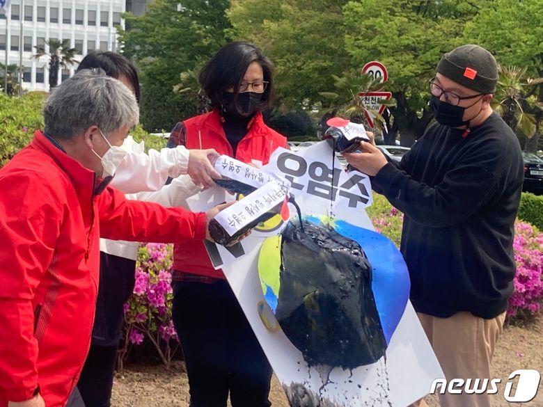 진보당 경남도당 기자회견 참가자들이 지구 모형 위에 오염수를 뿌리는 퍼포먼스를 하고 있다. © 뉴스1 김다솜 기자