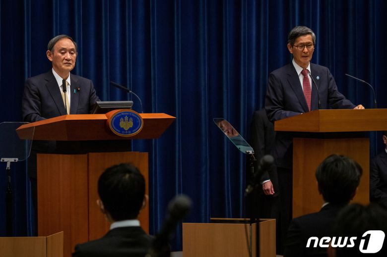 스가 요시히데 일본 총리(왼쪽)와 오미 시게루 코로나19 대책 분과회 회장. © 로이터=뉴스1