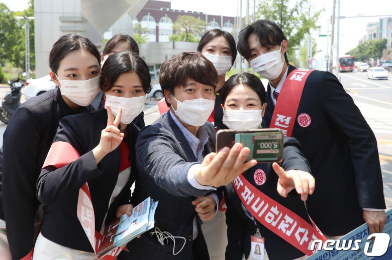 국민의힘 당 대표 출마를 선언한 이준석 전 최고위원이 24일 오후 대구 북구 경북대학교 북문 앞에서 대학생들과 인사 나누며 기념사진을 찍고 있다. 2021.5.24/뉴스1 © News1 공정식 기자