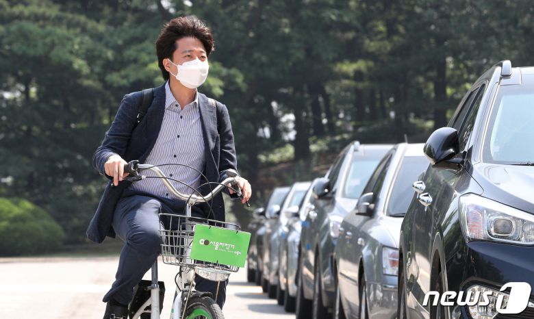 이준석 국민의힘 신임 대표가 13일 오전 서울 자전거 '따릉이'를 타고 서울 여의도 국회의사당역에서 국회로 첫 출근을 하고 있다. 대표실 한 관계자는 “이 대표는 평소에도 따릉이를 애용했으며, 당 대표 차량은 있으나 운전 기사를 아직 구하지 못했다”라고 전했다. 2021.6.13/뉴스1 © News1 구윤성 기자