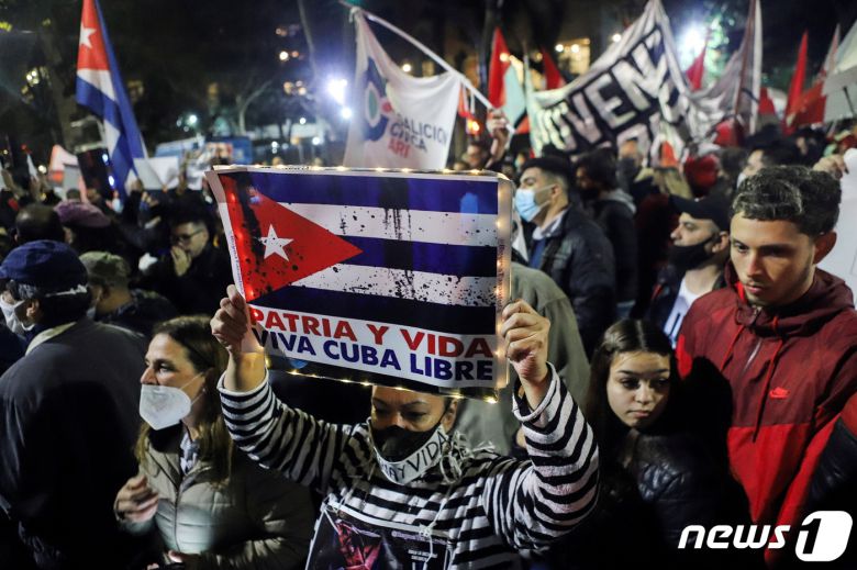 14일(현지시간) 아르헨티나 부에노스아이레스의 쿠바 대사관 앞에서 쿠바 정부에 항의하는 시위가 열렸다. 사람들이 쿠바 국기를 들며 행진하고 있다. © 로이터=뉴스1 © News1 이정후 기자