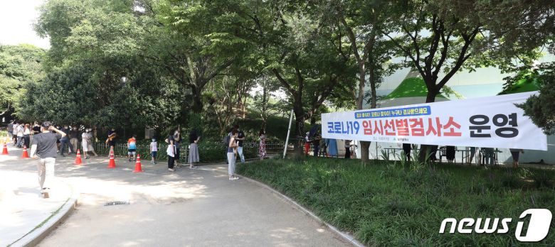 폭염이 이어진 23일 오후 대구 달서구 두류야구장 임시선별검사소에서 시민들이 줄지어 코로나19 진단검사를 기다리고 있다.  2021.7.23/뉴스1 © News1 공정식 기자