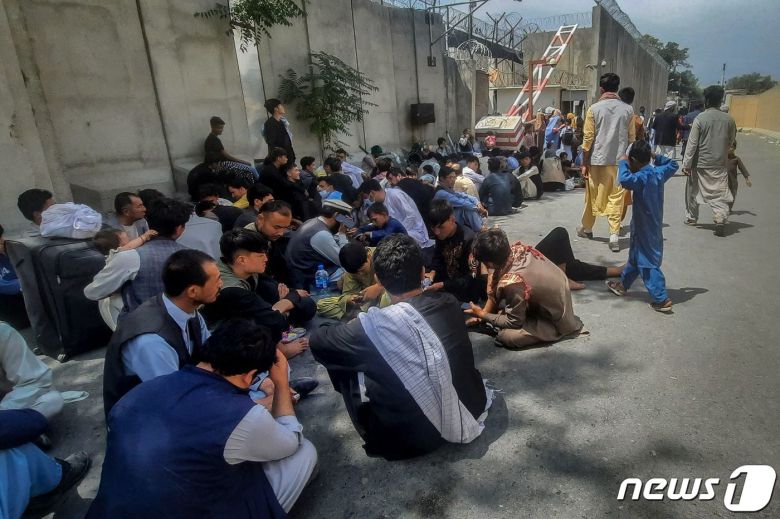 17일(현지시간) 탈레반이 아프가니스탄 정권을 재장악한 카불의 프랑스 대사관 밖에서 출국하려는 아프간인들이 앉아 있다. © AFP=뉴스1 © News1 우동명 기자