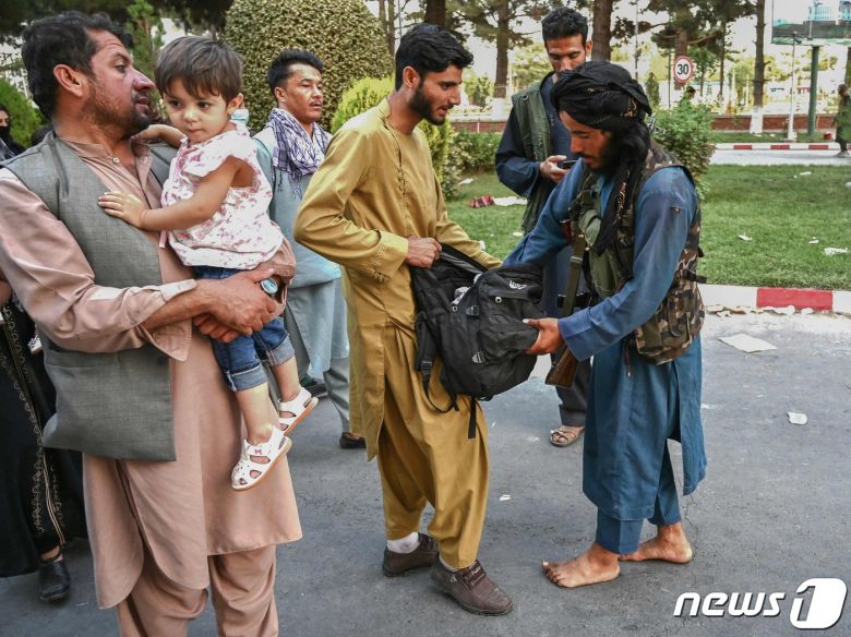 16일(현지시간) 아프가니스탄 정권 붕괴 후 수도 카불을 장악한 탈레반 조직원들이 공항으로 나온 시민의 가방을 수색하고 있다. © AFP=뉴스1 © News1 우동명 기자