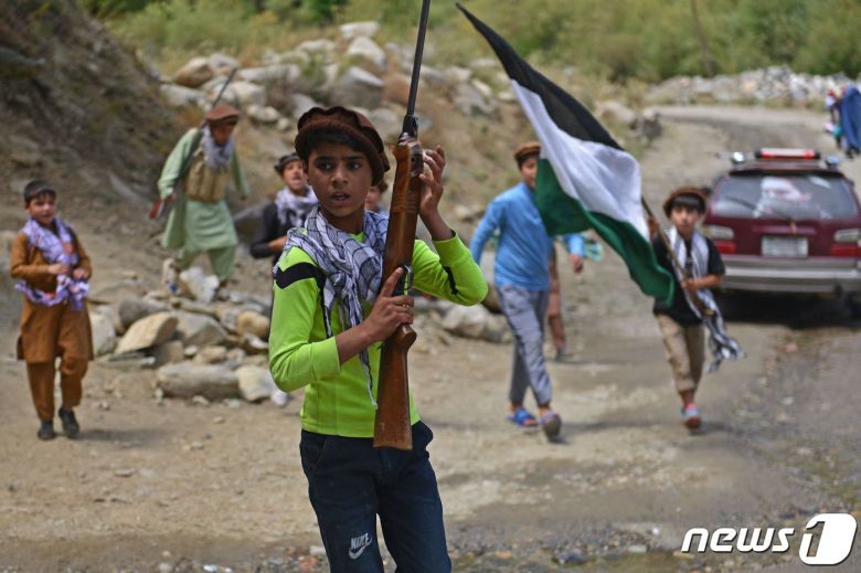 21일 (현지시간) 탈레반이 아프가니스탄을 장악한 뒤 판지시르주 다라에서 아프간 어린이들이 무기와 국기를 들고 있다. © AFP=뉴스1 © News1 우동명 기자