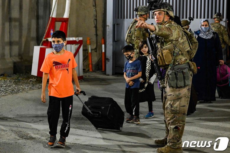 22일 아프가니스탄 카불 국제공항에서 미군들이 탈레반 점령을 피해 아프가니스탄을 탈출하는 사람들을 지원하고 있다. © AFP=뉴스1