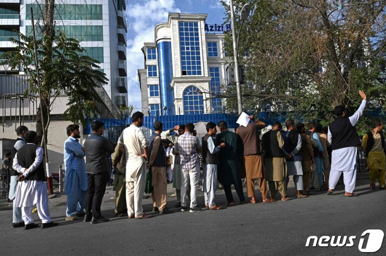 21일  탈레반이 아프가니스탄을 장악한 뒤 카불의 은행 ATM 앞에 주민들이 돈을 찾기 위해 줄을 서 있다. © AFP=뉴스1 © News1 우동명 기자