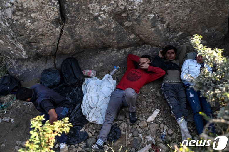 15일(현지시간) 아프간인들이 걸어서 터키 국경을 넘고 휴식을 취하고 있다. © AFP=뉴스1 © News1 구진욱 기자