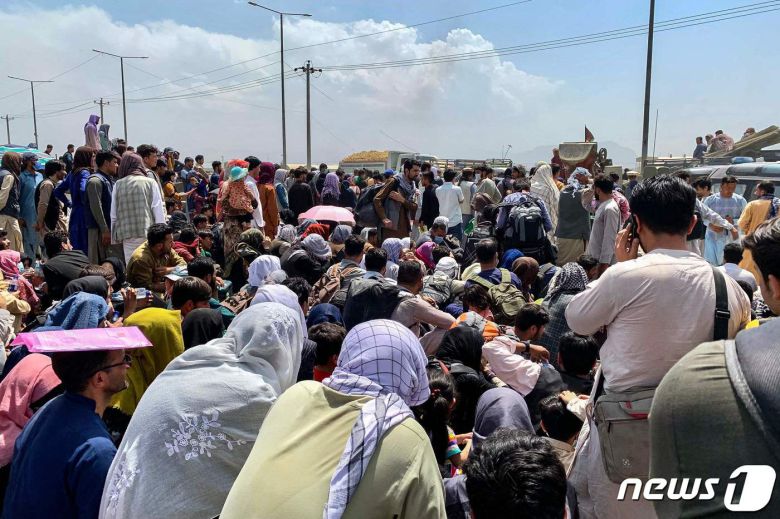 지난 20일 아프가니스탄 수도 카불 군 공항에 모여 미군 수송기 탑승을 기다리고 있는 피란민들.  © AFP=뉴스1