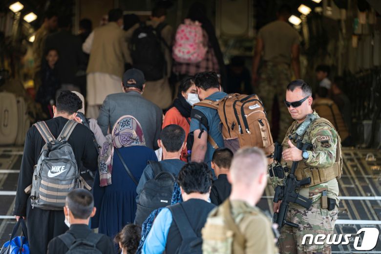 23일(현지시간) 카불 공항에서 아프간인들이 미군 수송기에 올라 대피하고 있다. © 로이터=뉴스1 © News1 정윤영 기자
