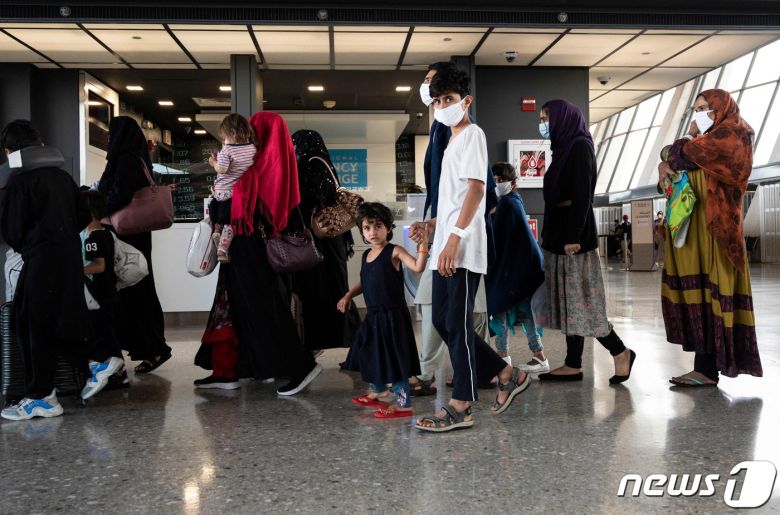 23일(현지시간) 미국 버지니아주 덜레스 국제공항에서 아프가니스탄 피난민들이 버스를 기다리고 있다. © AFP=뉴스1 © News1 구진욱 기자