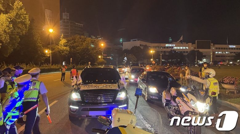 창원시청 앞 광장로타리에서 경남경찰이 ‘이제는 거리두기 BOYCOTT WITH 코로나’라는 문구의 플래카드를 부착하고 차량 시위에 나선 자영업자들의 차량 통행을 제지하고 있다.© 뉴스1