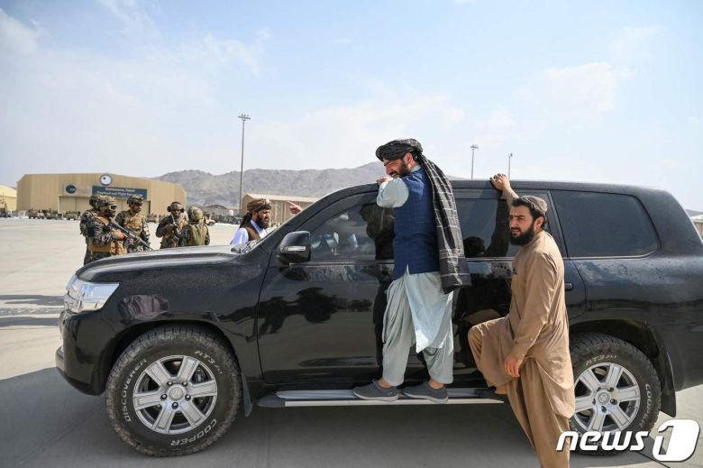 31일(현지시간) 미군이 철수를 완료한 아프가니스탄의 카불 공항에서 탈레반 전사들이 무장 차량 옆에 서 있다. © AFP=뉴스1 © News1 우동명 기자