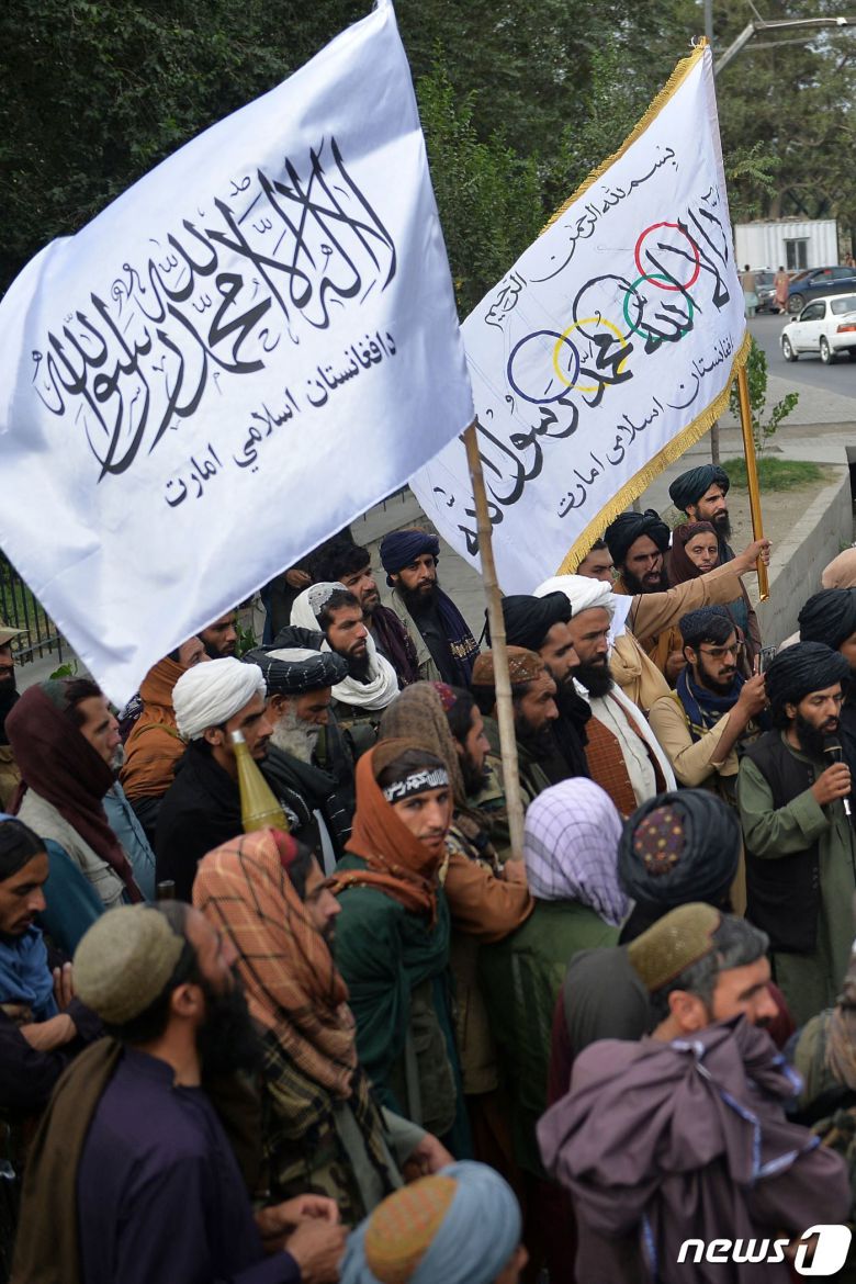 31일(현지시간) 미군이 철수를 완료한 아프가니스탄의 카불에서 소총을 든 탈레반 전사들이 탈레반 깃발을 들고 축하 집회에 참석을 하고 있다. © AFP=뉴스1 © News1 우동명 기자