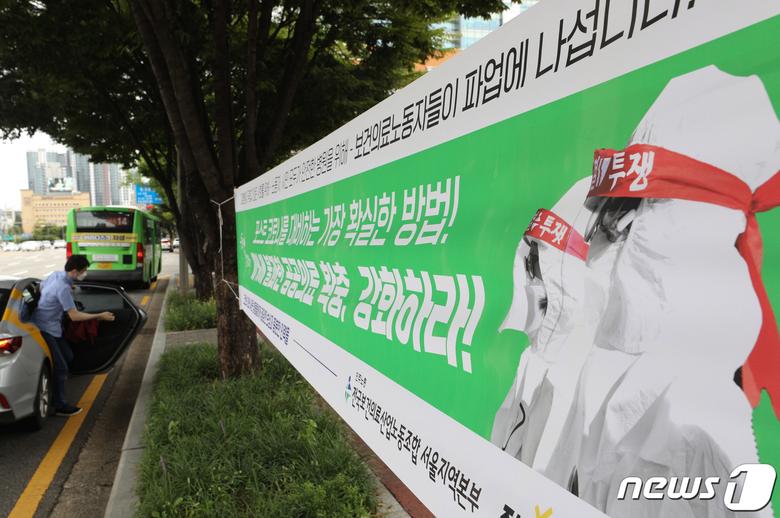 보건의료노조 총파업이 하루 앞으로 다가온 1일 오후 서울 서초구 성모병원에 보건의료노조 총파업을 알리는 현수막이 게시되어 있다. 보건의료노조는 공공의료 확충과 보건의료 인력 확대 등을 요구하며 보건복지부와 12번 만나 협상을 벌였지만 결론을 내리지 못했다. 이번 총파업으로 의료현장을 떠나는 보건의료인은 보건의료노조 측에서 밝힌 조합원을 포함하더라도 최소 8만명 이상이 될 것으로 보인다. 특히 이번 파업에는 국립중앙의료원과 서울아산병원 등을 포함한 감염병 전담병원과 거점전담병원들도 참여한다고 의사를 밝히면서 코로나19 대응에는 차질을 빚을 것으로 보인다. 2021.9.1/뉴스1 © News1 신웅수 기자