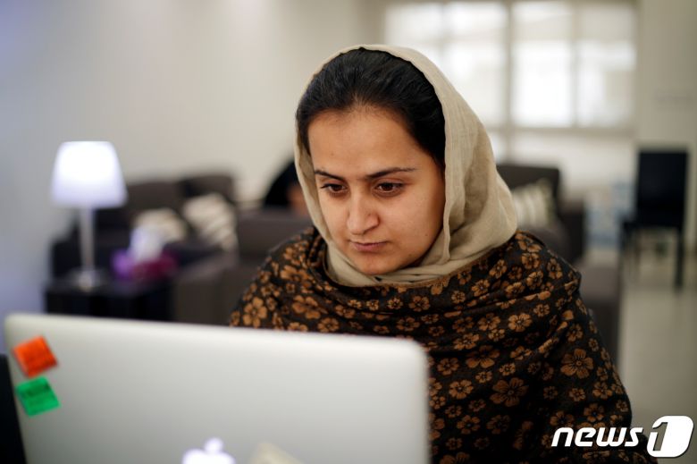 탈레반 고위간부와 처음으로 인터뷰를 했던 여성 앵커 베헤슈타 아르단드가 아프간을 탈출했다. 도하에 있는 임시거처에서 노트북을 열고 있다. © 로이터=뉴스1 © News1 박형기 기자