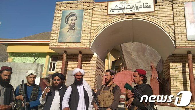 저항 세력의 최후 거점 판지시르를 장악한 탈레반이 2021년 9월 6일 저항군의 '대부' 아흐마드 샤 마수드 장군 초상화 아래에서 기념 사진을 찍고 있다. 마수드 장군은 1기 탈레반 집권기 북부동맹을 결성해 항쟁하다 2001년 9·11을 이틀 앞두고 암살된 저항 세력의 '영웅'이다. © 로이터=뉴스1 © News1 최서윤 기자