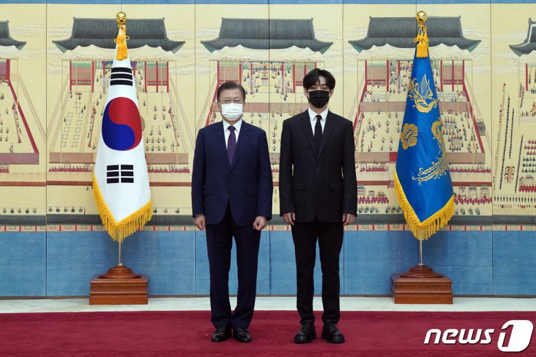 문재인 대통령이 14일 청와대에서 열린 미래세대와 문화를 위한 대통령 특별사절 임명장 수여식에서 아이돌 그룹 방탄소년단(BTS) 멤버 뷔(김태형)에게 임명장을 수여하고 기념촬영을 하고 있다. 2021.914/뉴스1 © News1 유승관 기자