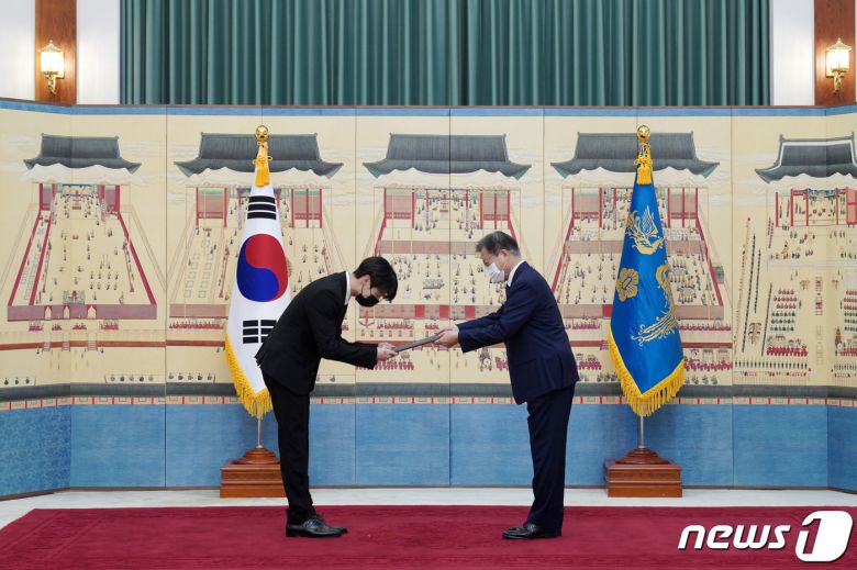 문재인 대통령이 14일 청와대에서 열린 미래세대와 문화를 위한 대통령 특별사절 임명장 수여식에서 아이돌 그룹 방탄소년단(BTS) 멤버 정국(전정국)에게 임명장을 수여하고 외교여권과 기념품을 전달하고 있다. 2021.914/뉴스1 © News1 유승관 기자
