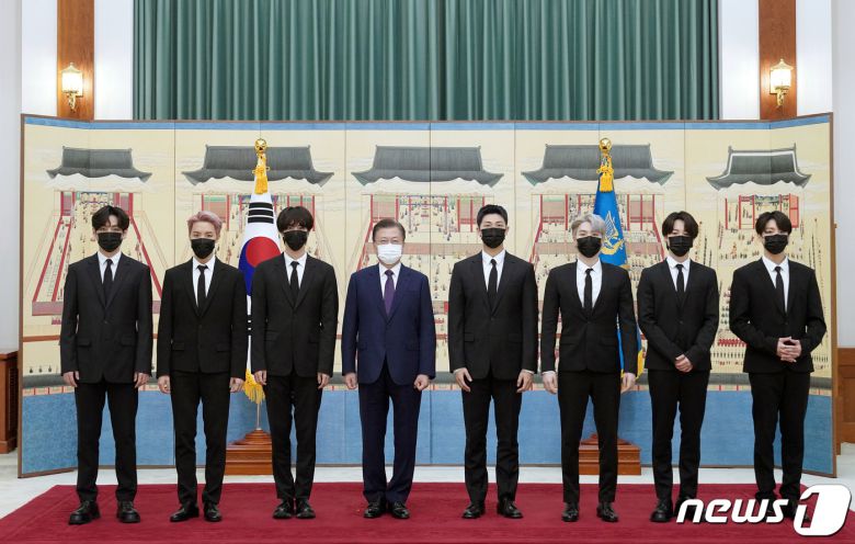 문재인 대통령이 14일 청와대에서 열린 미래세대와 문화를 위한 대통령 특별사절 임명장 수여식에서 아이돌 그룹 방탄소년단(BTS)에게 임명장을 수여하고 기념촬영을 하고 있다. 왼쪽부터 뷔, 제이홉, 진, 문 대통령, RM, 슈가, 지민, 정국. 2021.914/뉴스1 © News1 유승관 기자