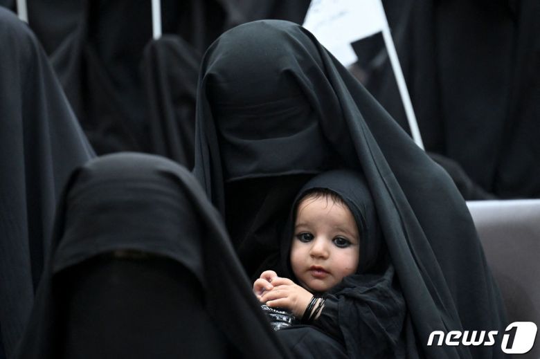 11일(현지시간) 아프가니스탄 수도 카불 소재 샤히드 라바니 교육대에서 열린 여성 권리 향상을 위한 집회에 한 여성이 부르카를 쓰고 자신의 아이와 함께 참석했다. 2011.09.11 © AFP=뉴스1