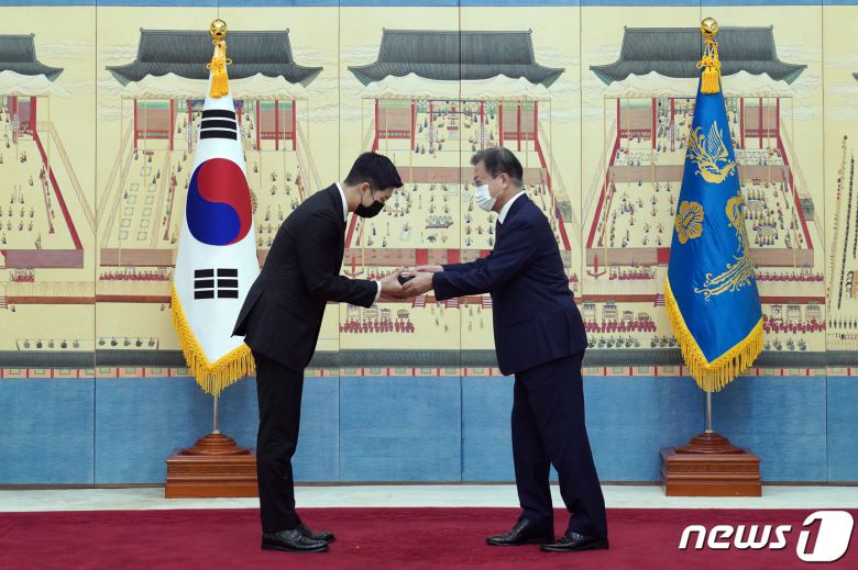 문재인 대통령이 14일 청와대에서 열린 미래세대와 문화를 위한 대통령 특별사절 임명장 수여식에서 아이돌 그룹 방탄소년단(BTS) 멤버 RM(김남준)에게 임명장을 수여하고 외교여권과 기념품을 전달하고 있다. 2021.914/뉴스1 © News1 유승관 기자