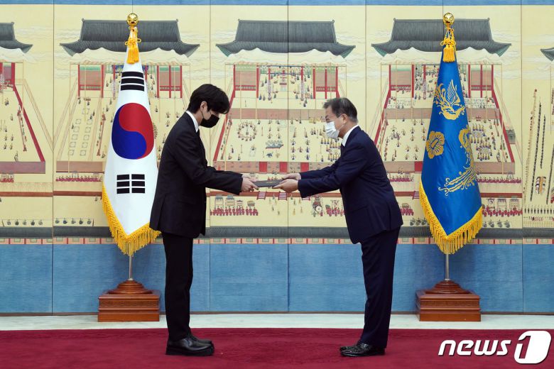 문재인 대통령이 14일 청와대에서 열린 미래세대와 문화를 위한 대통령 특별사절 임명장 수여식에서 아이돌 그룹 방탄소년단(BTS) 멤버 뷔(김태형)에게 임명장을 수여하고 외교여권과 기념품을 전달하고 있다. 2021.914/뉴스1 © News1 유승관 기자