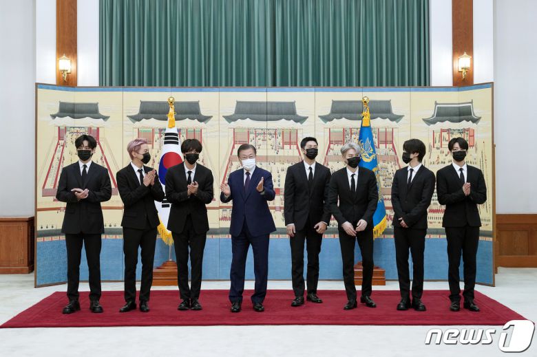 문재인 대통령이 14일 청와대에서 열린 미래세대와 문화를 위한 대통령 특별사절 임명장 수여식에서 아이돌 그룹 방탄소년단(BTS)에게 임명장을 수여하고 기념촬영을 하고 있다. 왼쪽부터 뷔, 제이홉, 진, 문 대통령, RM, 슈가, 지민, 정국. 2021.914/뉴스1 © News1 유승관 기자