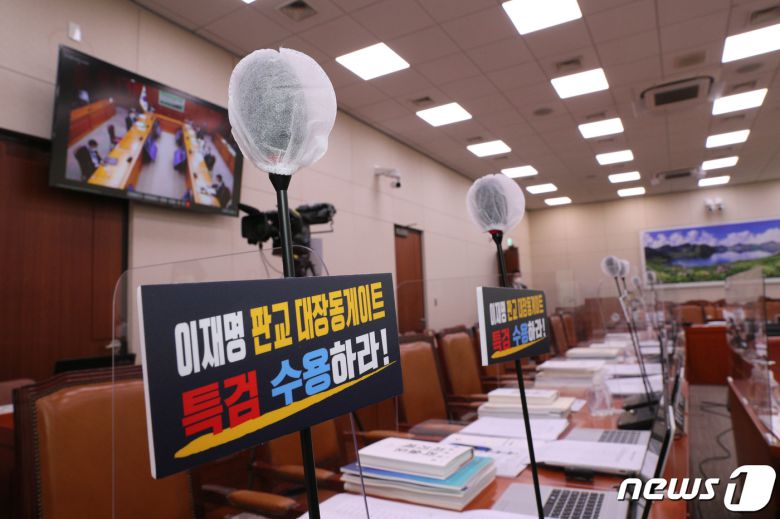 1일 오전 서울 여의도 국회에서 열린 외교통일위원회의 외교부·한국국제협력단·한국국제교류재단·재외동포재단 등에 대한 국정감사에서 국민의힘 의원들이 '대장동 개발 특혜 의혹'과 관련해 특검을 요구하는 손팻말을 붙이고 마이크를 세우며 항의하고 있다. 이날 오전 열린 외교통일위원회를 비롯한 상임위 국정감사 대부분이 파행을 겪고 있다. 2021.10.1/뉴스1 © News1 구윤성 기자