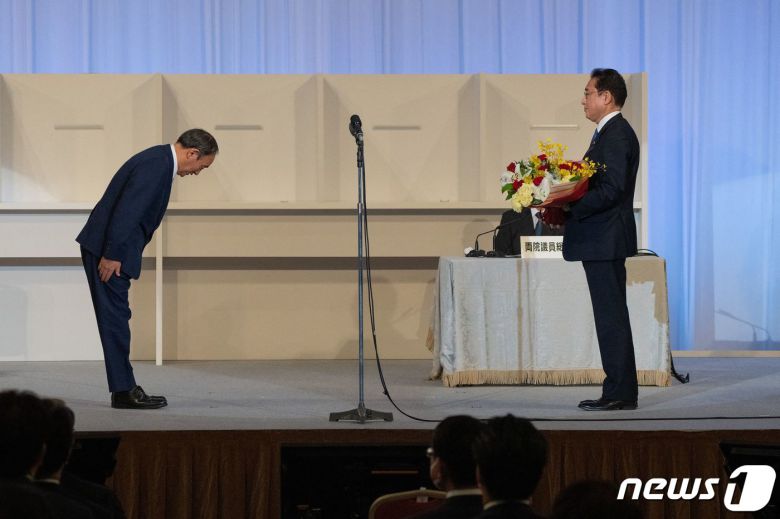 기시다 후미오 신임 자민당 총재가 29일 (현지시간) 도쿄에서 총재에 선출된 뒤 물러나는 스가 요시히데 총리의 인사를 받고 있다. 기시다 총재는 내달 초 의회 선출 절차를 거쳐 총리로 정식 취임한다. © AFP=뉴스1 © News1 우동명 기자