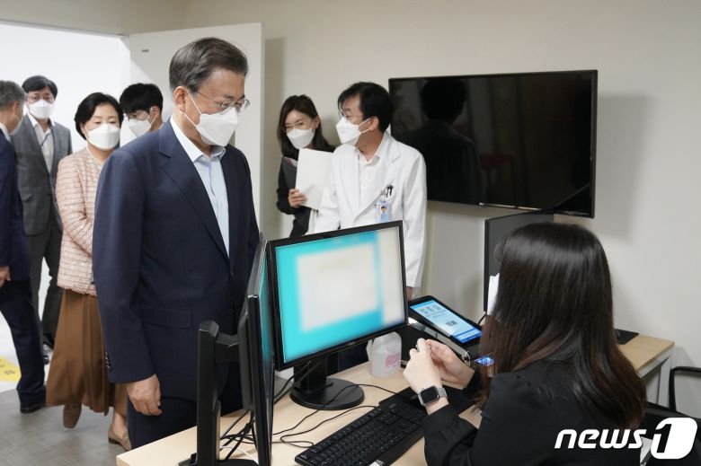 문재인 대통령과 김정숙 여사가 15일 코로나19 백신 추가 접종을 받기 위해 서울 국립중앙의료원 코로나19 중앙예방접종센터를 찾아 본인 확인 절차를 밟고 있다.2021.10.15/뉴스1 © News1 이광호 기자