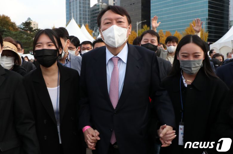 윤석열 국민의힘 대선 후보가 6일 오후 서울 송파구 올림픽공원 평화의광장에서 열린 2021 대한민국 청년의날 행사를 마치고 청년들 손을 잡고 걷고 있다. 2021. 11.6/뉴스1 © News1 김명섭 기자