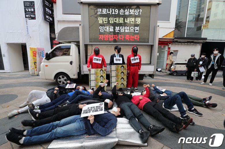 소상공인들이 27일 오전 서울 중구 명동거리에서 '코로나19 임대료를 멈춰라' 캠페인 돌입 기자회견을 갖고 명동 바닥에 누워 퍼포먼스를 하고 있다. 한국자영업자협의회, 한국중소상인자영업자총연합회 등 소상공인 단체는 자영업자 손실보상금 상당부분이 임대료에 고스란히 쓰이면서 건물주에게 돌아간다고 주장하며 임대료를 멈출 것을 촉구했다. 2021.10.27/뉴스1 © News1 박세연 기자