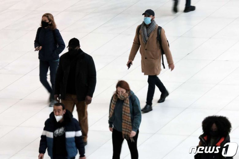 13일 뉴욕 맨해튼의 행인들이 마스크를 쓴 채 걷고 있다. © AFP=뉴스1
