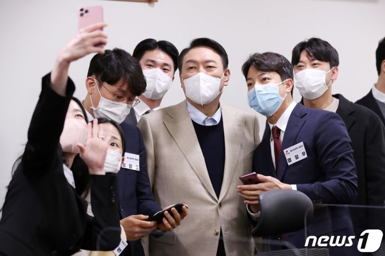 윤석열 국민의힘 대선 후보가 18일 서울 여의도 국회의원회관에서 열린 청년보좌역 공개 모집 현장을 격려 방문해 면접자들과 셀카를 찍고 있다. 2021.12.18/뉴스1 © News1 민경석 기자