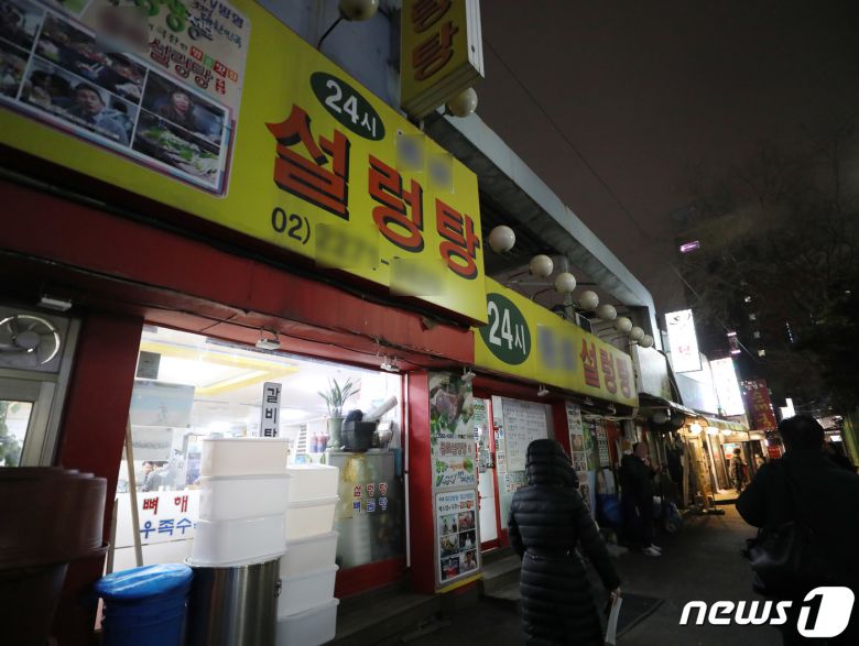 코로나피해자영업총연합(코자총)이 정부의 방역지침 강화에 항의해 간판과 입간판을 끄는 소등 시위를 시작한 27일 저녁 서울 도심의 먹자골목에서 상인들이 소등 시위에 참여하고 있다.  2021.12.27/뉴스1 © News1 박정호 기자