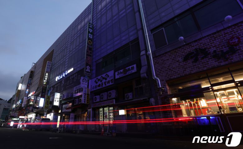 27일 오후 경기도 수원시 영통구의 한 먹자골목에서 상인들이 간판을 소등하고 영업을 하고 있다. 코로나피해자영업총연합(코자총)은 오늘부터 내일까지 오후 5시부터 4시간 동안 건물 노출 간판과 입간판을 모두 끄고 영업하는 소등 시위를 할 계획이라고 밝혔다. 2021.12.27/뉴스1 © News1 김영운 기자