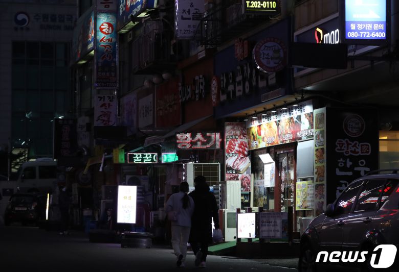 27일 오후 경기도 수원시 영통구의 한 먹자골목에서 상인들이 간판을 소등하고 영업을 하고 있다. 코로나피해자영업총연합(코자총)은 오늘부터 내일까지 오후 5시부터 4시간 동안 건물 노출 간판과 입간판을 모두 끄고 영업하는 소등 시위를 할 계획이라고 밝혔다. 2021.12.27/뉴스1 © News1 김영운 기자