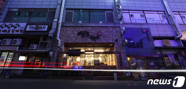 27일 오후 경기도 수원시 영통구의 한 먹자골목에서 상인들이 간판을 소등하고 영업을 하고 있다. 2021.12.27/뉴스1 © News1 김영운 기자
