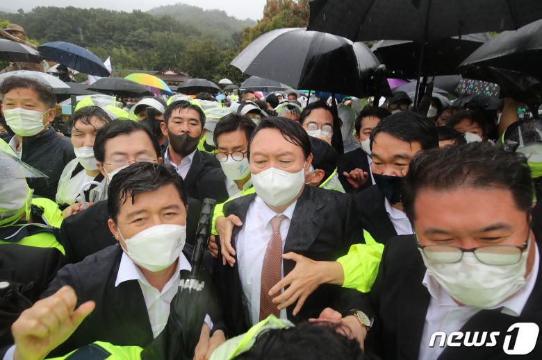 윤석열 국민의힘 대선 경선 후보가 17일 오전 경북 구미시 박정희 전 대통령 생가를 찾아 추모관 참배를 마친 뒤 경찰의 호위를 받으며 생가를 떠나고 있다. 이날 박 전 대통령 생가 방문과 박근혜 전 대통령 구속에 항의하는 보수단체 회원들이 대거 몰려 생가 진·출입로를 막는 등 혼잡이 빚어졌다. 2021.9.17/뉴스1 © News1 공정식 기자