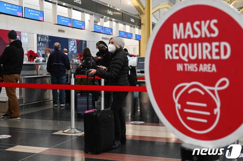 27일(현지시간) 미국 워싱턴D.C 소재 로널드레이건 국제공항에서 마스크를 쓴 여행객들이 탑승 수속을 밟기 위해 대기하고 있다. 2021.12.27 © AFP=뉴스1