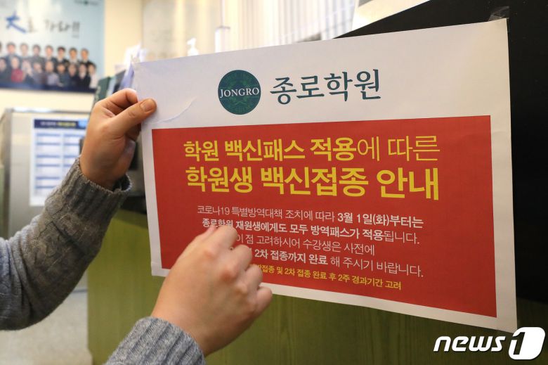 4일 오후 서울 마포구 종로학원 강북본원에서 관계자가 방역패스 관련 안내문을 떼고 있다. 이날 법원이 학원과 독서실 등을 대상으로 하는 정부의 방역패스(접종증명·음성확인제) 대책에 제동을 걸었다.  2022.1.4/뉴스1 © News1 임세영 기자