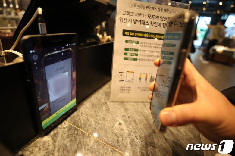 '방역패스(접종증명·PCR음성확인)'에 백신 유효기간을 적용한 첫날인 1월3일 서울 시내 스타벅스 커피 매장에 한 시민이 큐알(QR) 코드 스캔과 방역패스 유효 상태를 체크하고 있다. 2022.1.3/뉴스1 © News1 김진환 기자