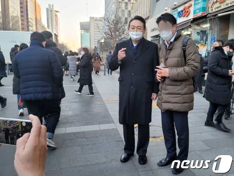 윤석열 국민의힘 대선후보가 6일 오전 서울 영등포구 여의도역 인근에서 출근길 인사를 하며 시민들과 사진을 찍고 있다. 2022.1.6/뉴스1 © News1 박기범 기자