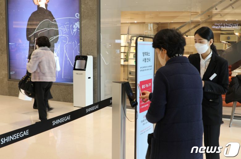 대형마트·백화점에 신종 코로나바이러스 감염증(코로나19) 방역패스 의무화가 적용된 첫날인 10일 오전 10시30분 부산 해운대구 신세계백화점 센텀시티점 입구에서 방문객이 QR코드 인증을 하고 있다.2022.1.10/뉴스1 © News1 이유진 기자