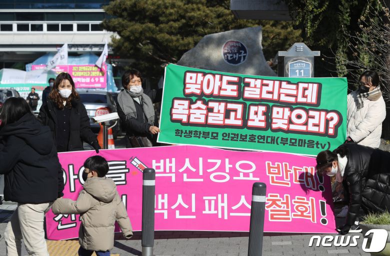 지난 4일 오전 대구시교육청 앞에서 아이들 백신강요를 반대하고 전국민 백신패스 철회를 촉구하는 '학생상대 강제백신 반대집회' 현장에서 한 아이와 엄마가 지나고 있다. 2022.1.4/뉴스1 © News1 공정식 기자