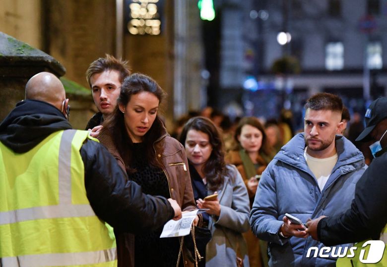 영국 런던에서 2021년 12월 31일 코로나19 확산 속 나이트클럽에 입장하려는 사람들이 신분증과 백신 패스 검사를 받고 있다. © 로이터=뉴스1 © News1 최서윤 기자
